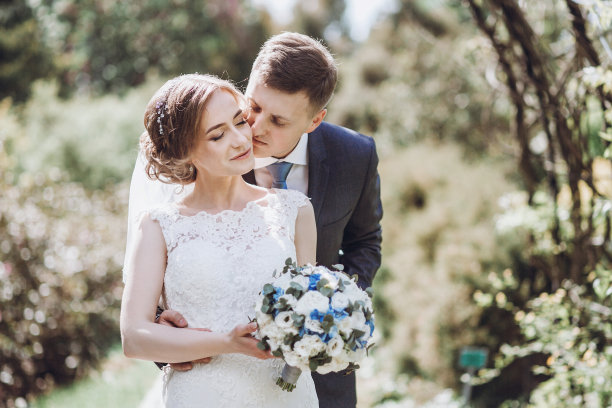 可爱的新婚夫妇在公园亲吻，快乐的新娘和新郎在户外夏日花园拥抱，美丽的女人和英俊的男人浪漫的时刻图片下载