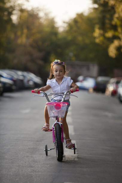 可爱的女孩在户外骑自行车图片下载