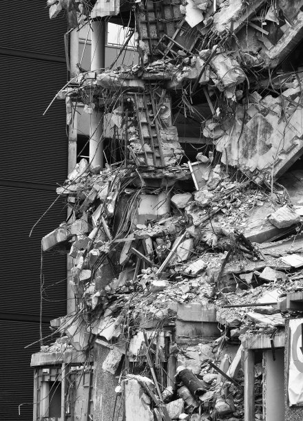 一个被毁的现代混凝土高层建筑等待拆除的单色图像图片下载