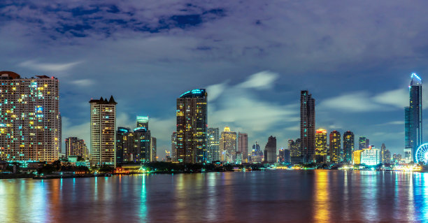 城市景观的现代建筑附近的河流在夜间。现代建筑办公楼。有夜空的摩天大楼。黑白色调图片。江边建筑夜景摄影。图片下载