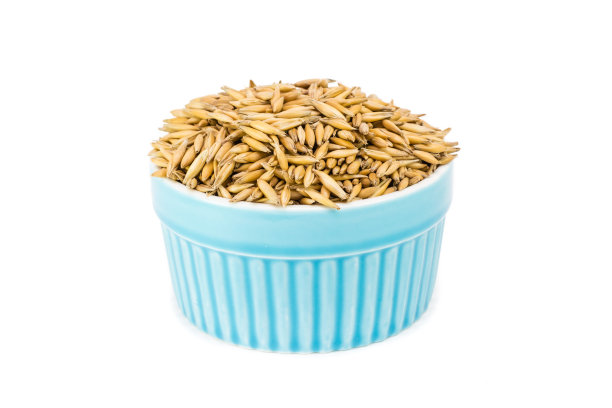 白色背景的碗里的生燕麦粒图片下载