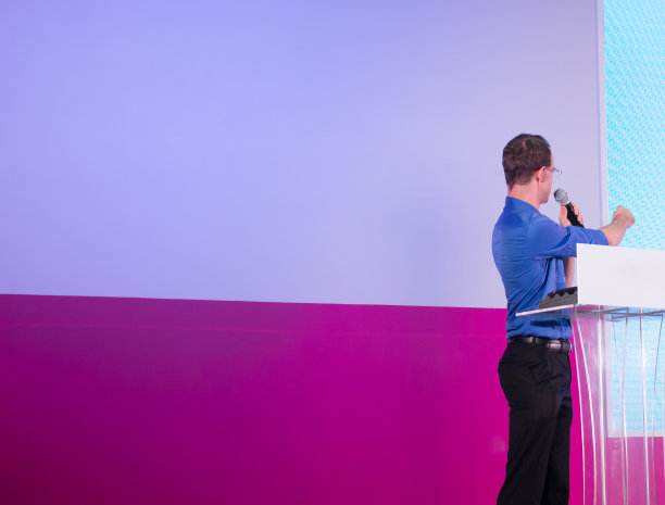 在向观众演讲时，手臂和手指向屏幕。商业讲座主讲人上台。教师上台演讲。空白背景复制空间。经理。图片下载