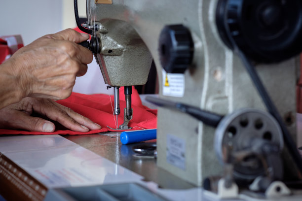 女人在旧缝纫机上缝补织物图片下载
