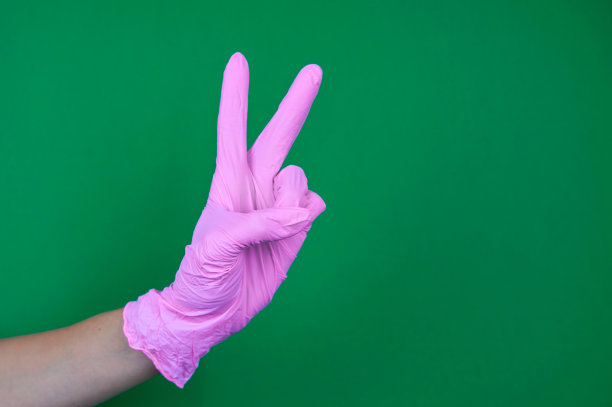 在绿色背景上戴上粉色手套图片下载