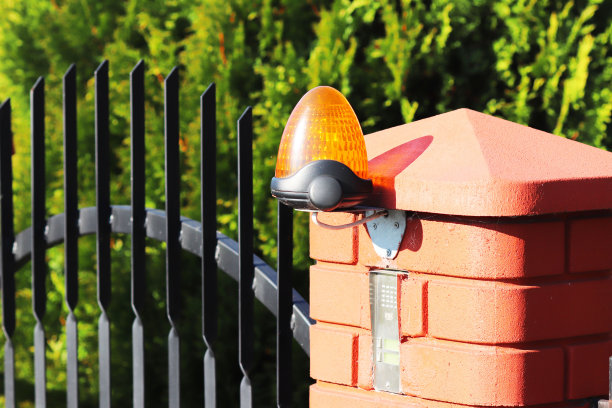 橙色的房间报警灯位于一个砖栅栏柱上。位于私人保护区入口的对讲机公寓大楼。危险警告。门帘用对讲机。财产保护与安全图片下载