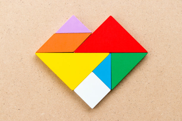 彩色七巧板在木背景心形拼图图片下载