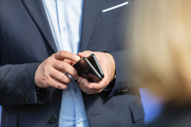 商人拿着两部手机图片下载