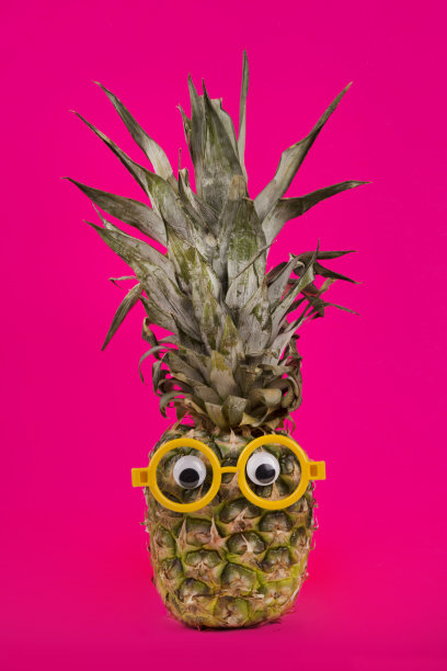 时尚新鲜菠萝与眼镜在粉红色的背景。图片下载