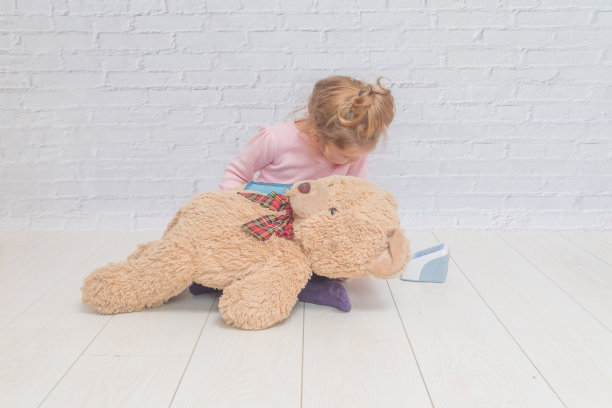 孩子玩医生，测量一个熊玩具的压力图片下载