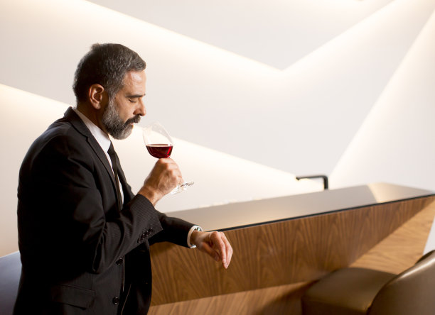 英俊成熟的男人品尝红酒图片下载
