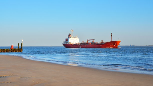 红色的货轮和大海下多云的蓝天图片下载