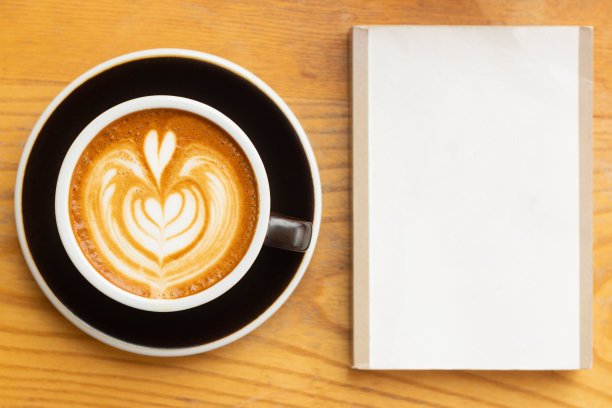 木桌上放着拿铁咖啡和太空书图片下载