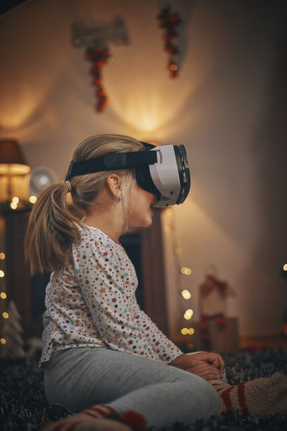 在舒适的圣诞氛围中，小女孩在客厅玩VR眼镜图片下载