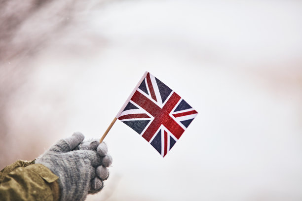女人举着英国国旗在雪景图片下载