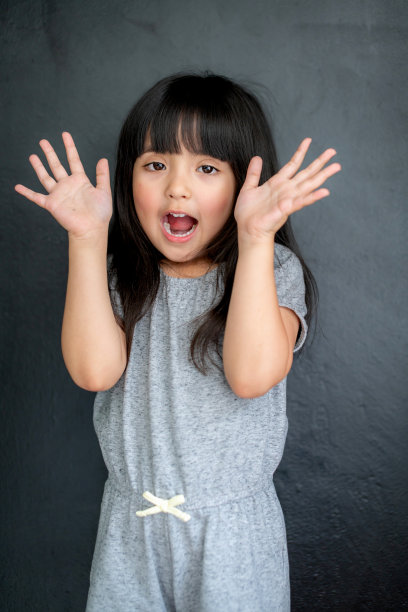 幸福黑头发亚洲大眼睛女孩肖像照片拍摄与休闲服装与有趣的黑色屏幕背景图片下载