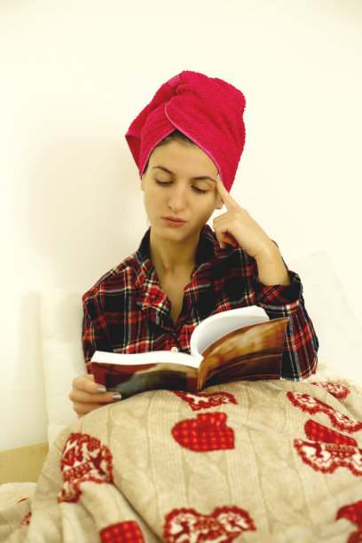 年轻女子在床上看书图片下载