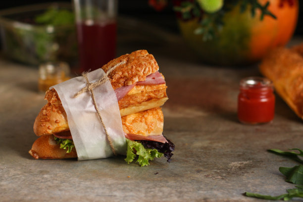 夹有面包卷、生菜、香肠和火腿的三明治，在木制的背景上。野餐的食物。俯视图图片下载