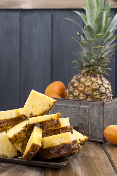 菠萝和桃子装在一个金属盒子里，木质背景。维生素和夏季排毒。复古的照片。警察的空间图片下载