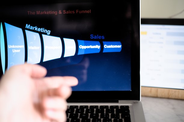 市场营销漏斗显示在电脑显示器上，男性手指着屏幕。图片下载