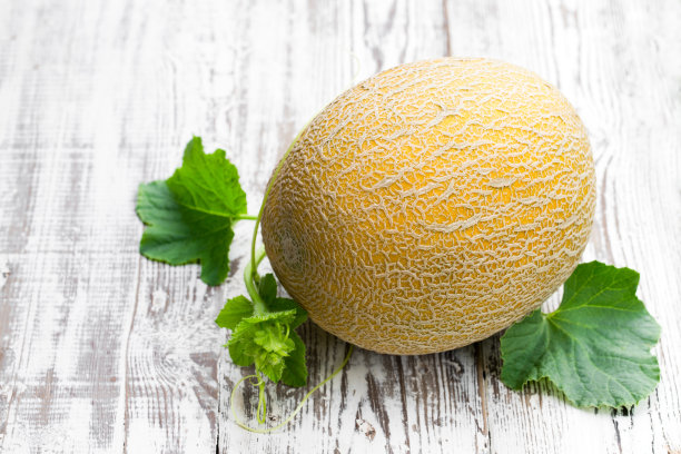 白木桌上有带小枝的蜜瓜图片下载