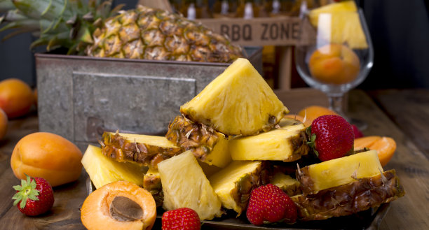 在宴会上用成熟的热带水果做果汁和鸡尾酒。一盒啤酒和木制背景。复古的照片。本空间图片下载