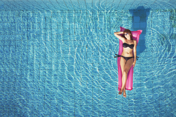 俯视图的女人在比基尼游泳在海滩游泳池图片下载