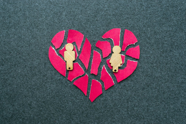 分手，离婚，失败的感情观念。破碎的马赛克，粉红色的心和木制的男人和女人在灰色的背景。图片下载