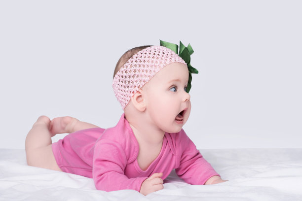 可爱的小女孩，头上戴着蝴蝶结花，孤立在灰色图片下载