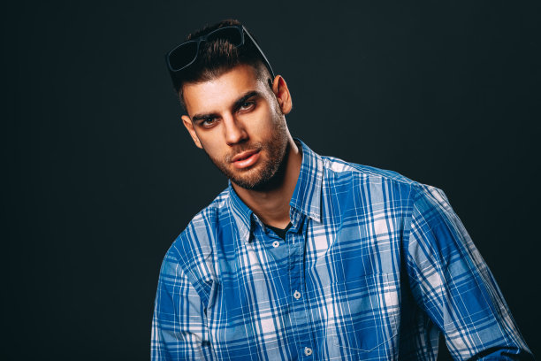 一个戴着墨镜的帅哥在黑暗的背景下拍照图片下载