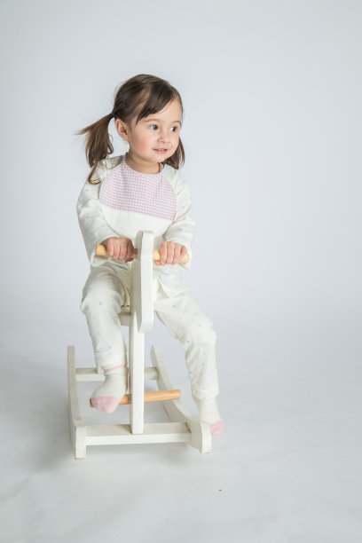 这个漂亮的小女孩骑着一匹木马图片下载