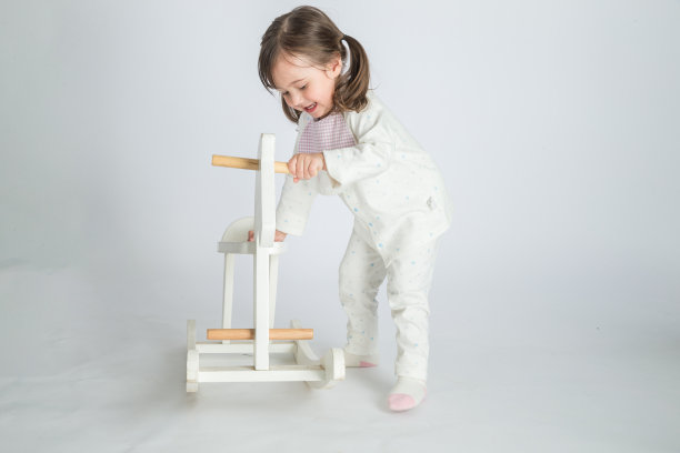 这个漂亮的小女孩骑着一匹木马图片下载