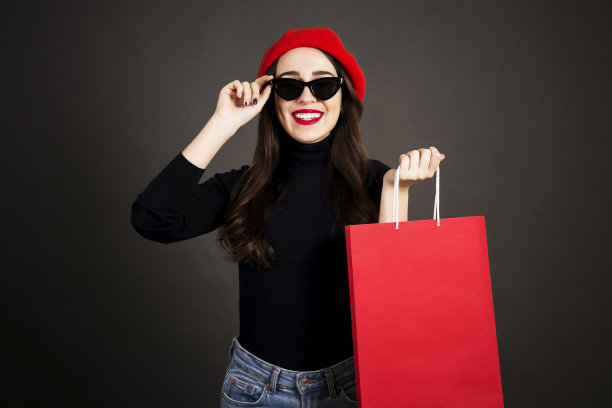 快乐的黑发女性与长头发在休闲服装摆姿势在灰色的黑色梯度背景。图片下载