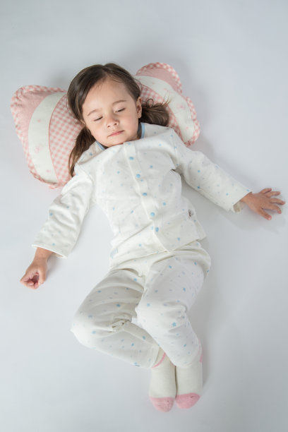 快乐的小女孩在家里的床上有一个枕头图片下载