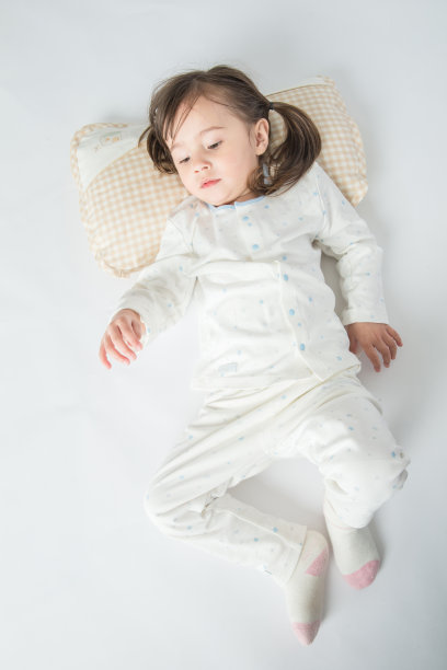 快乐的小女孩在家里的床上有一个枕头图片下载