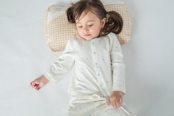 快乐的小女孩在家里的床上有一个枕头图片下载