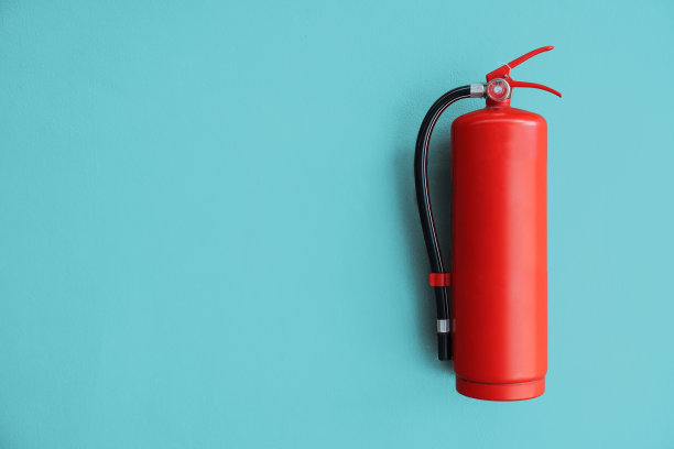 蓝色的墙上有红色的灭火器。图片下载