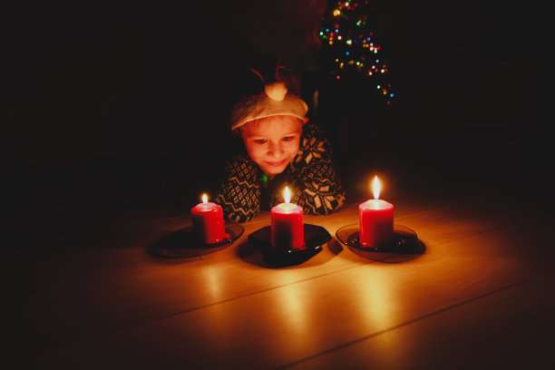 可爱的小男孩吹蜡烛在圣诞节许愿图片下载