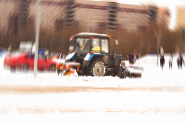 模糊不清的市政服务车辆耙着厚厚的积雪。圣彼得堡。俄罗斯。图片下载