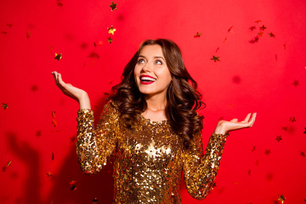 看起来像从天空落下的星星!女士与大白色喜气洋洋的微笑看一边与现代波浪发型孤立在生动的红色背景赢家图片下载