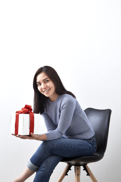 年轻的亚洲女子打开一个白色背景的礼品盒，图片包括拷贝空间图片下载