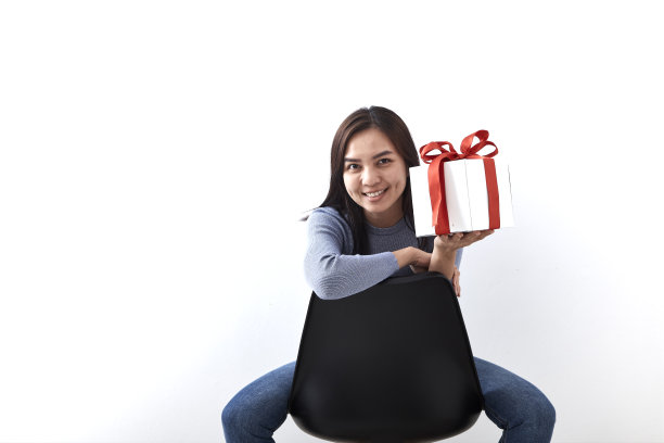 年轻的亚洲女子打开一个白色背景的礼品盒，图片包括拷贝空间图片下载