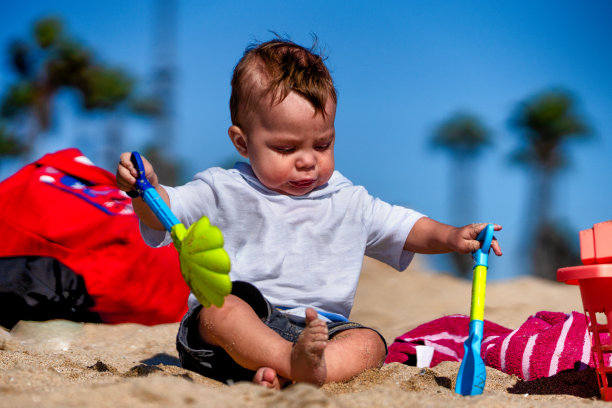 一岁男孩第一天在沙滩上玩沙子图片下载