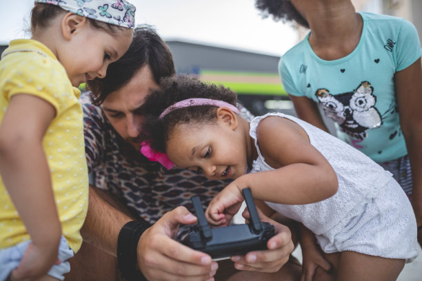 父亲和他的混血儿玩遥控无人机图片下载