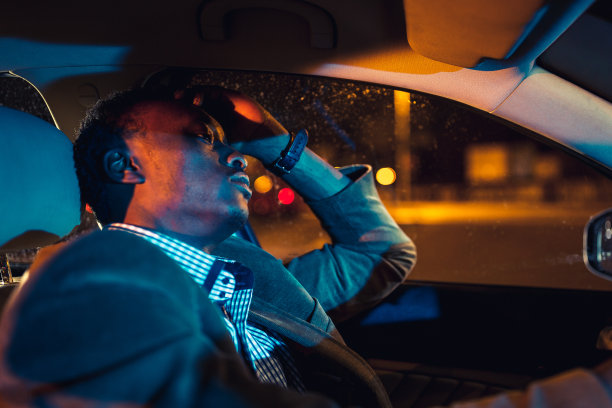 英俊的商人在出差，晚上开车。非洲的种族图片下载