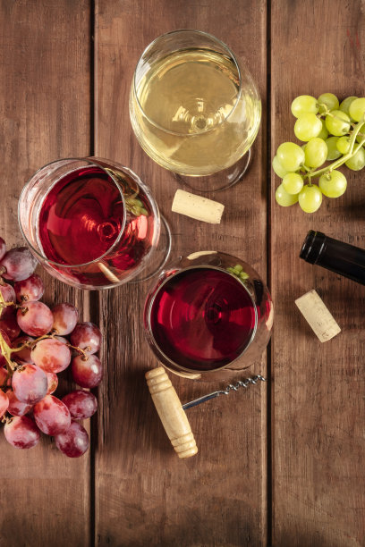 品酒。这是一张头顶上的照片，上面是红、玫瑰、白葡萄酒杯与酒瓶、葡萄和老式开瓶器的合影，拍摄地点是一个深色的乡村木制背景，有复制空间图片下载
