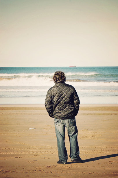 一名40岁的中年白人男子在阿根廷马德普拉塔的海滩上度假，看着地平线图片下载