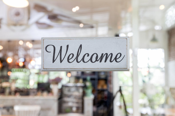 欢迎的标签是用旧木头做的吗?欢迎指示牌特写透过玻璃的咖啡店门。图片下载