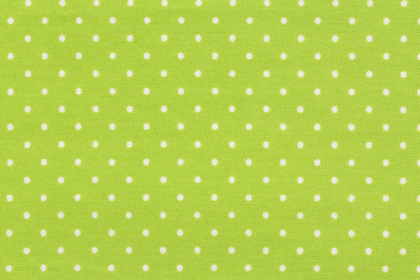 白色圆点在黄色圆点织物的背景和纹理。图片下载