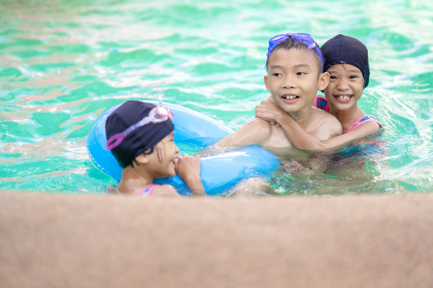 快乐的孩子们在环橡胶安全的游泳池里玩耍和游泳图片下载