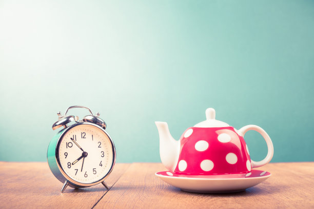 桌子上有圆点的旧闹钟和茶壶。复古风格滤镜照片图片下载